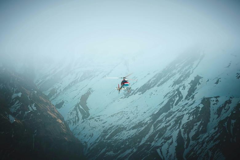Helicopter in Snowy and Foggy Mountain Landscape